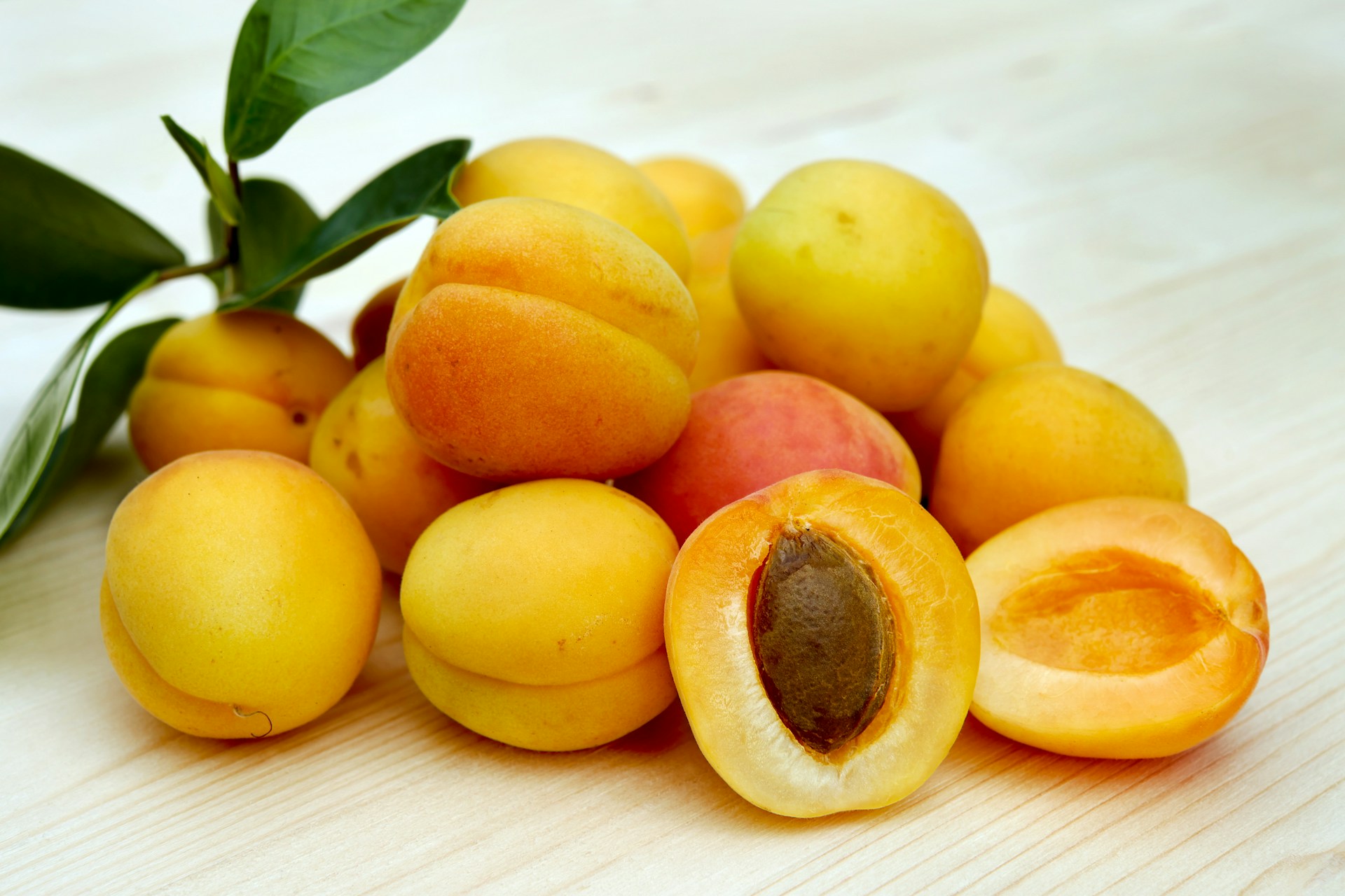 Apricots on a table with one open to show the stone