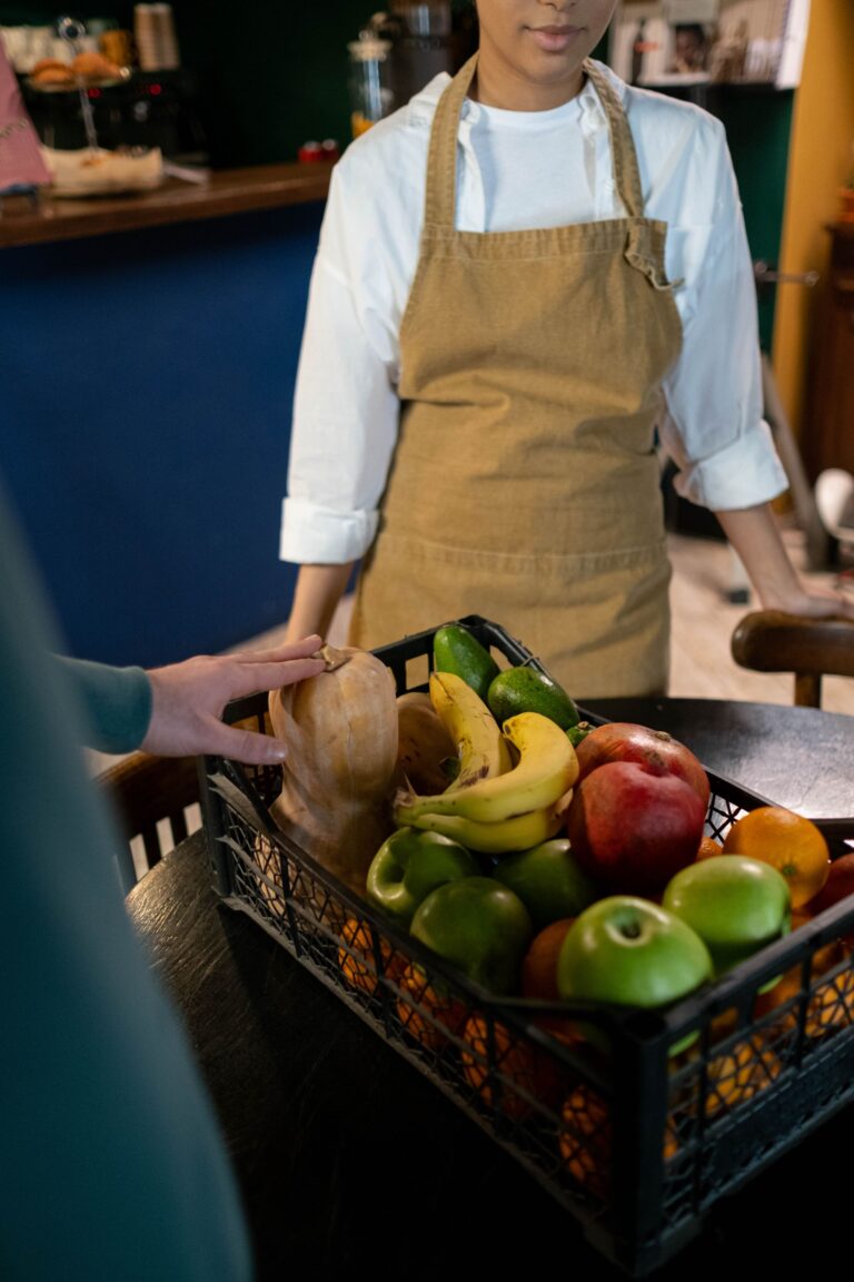 chef with fresh fruits and vegetables in a crate on the counter